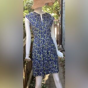 Sleeveless blue cotton summer dress, with green and white floral motif. Small